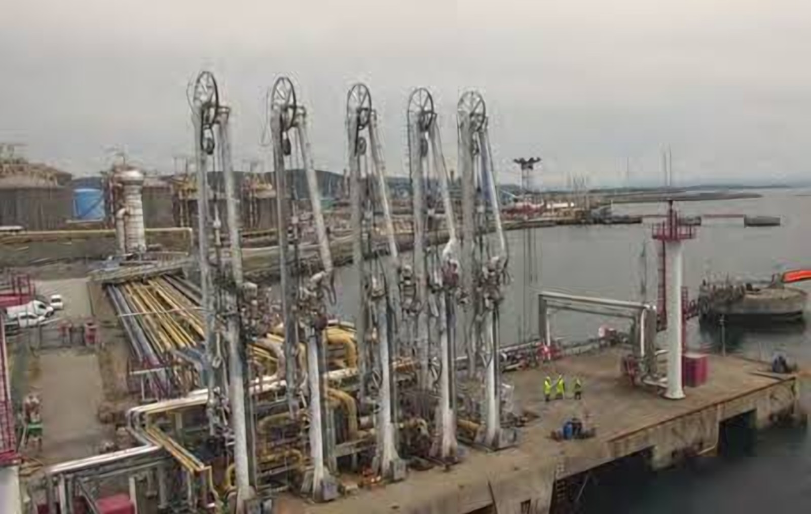 Row of marine loading arms on a refinery jetty